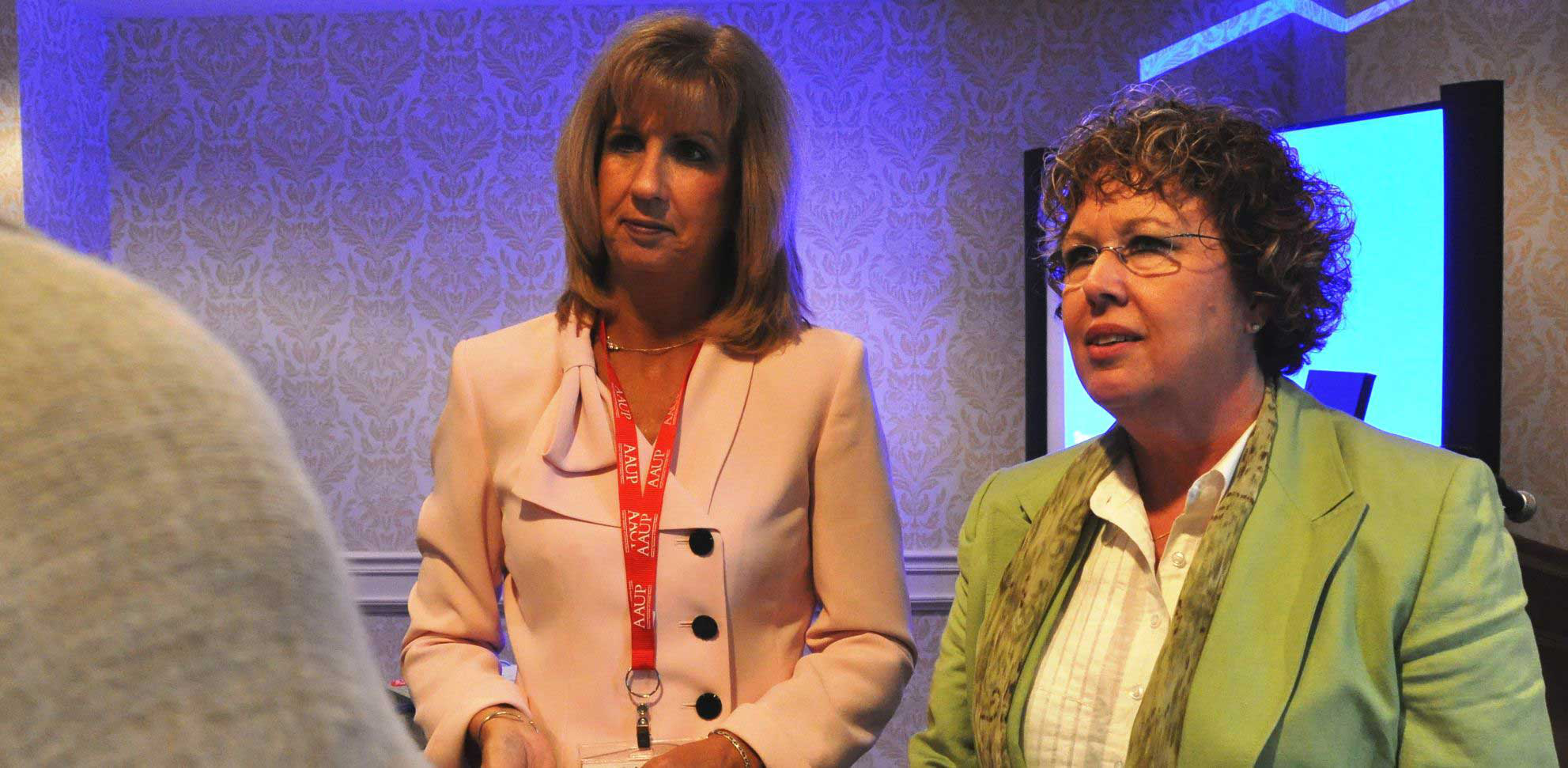 Janet McMahon (left) and Faith Edwards (right) speak to attendee during the American Association of University Professors annual national conference. (photo by Arelis Hernandez)