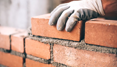 close-up-of-industrial-bricklayer-installing-bricks-on-construction-site