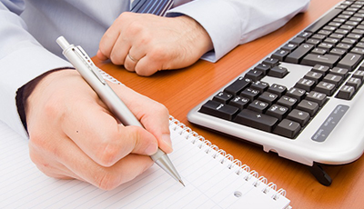 Business man writing in a notebook.