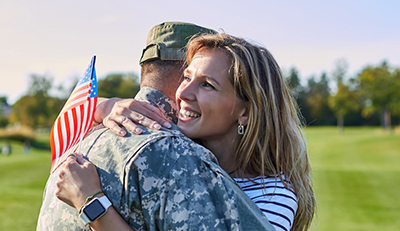 American soldier is hugging with wife.