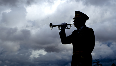 Silhouette of bugle player.