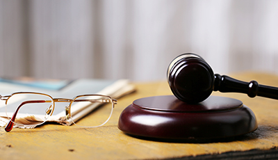 Labor law concept, gavel, glasses and newspaper on wooden table