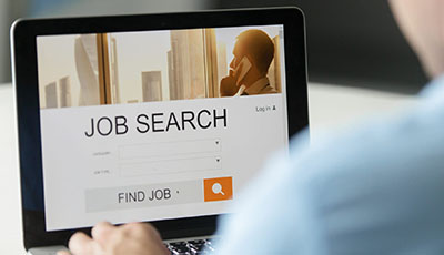 Monitor view over a male shoulder, job search title