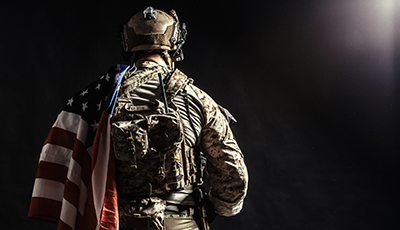 Soldier holding machine gun with national flag
