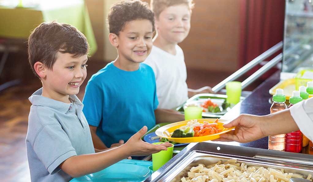 Cropped image of woman serving food to children