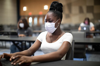 student-in-mask-on-computer-in-class