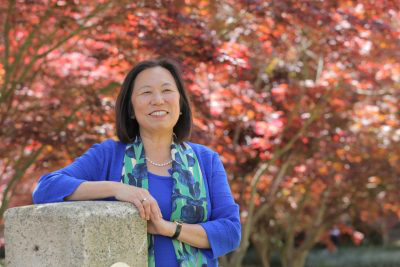 Judy with autumn tree background smile