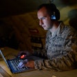 Senior Airman Ryan Zeski uses time during a long flight to work on some homework for a course he is taking at Oakland University.
