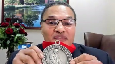 Dr. Freeman Hrabowski holds up his medal at Diverse's Dr. John Hope Franklin Award ceremony.