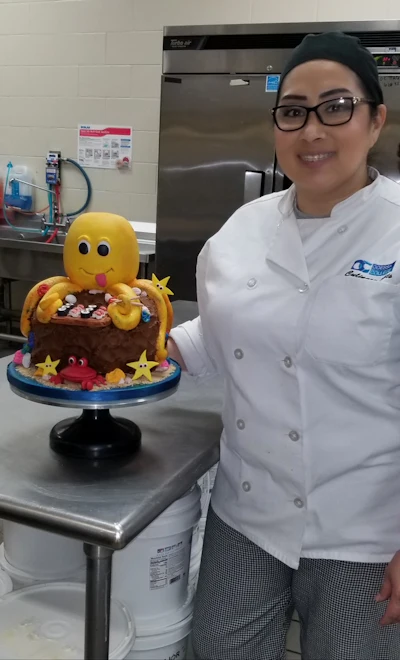 Stephanie Franco, standing next to her final project at Odessa College's Baking Level I Certificate