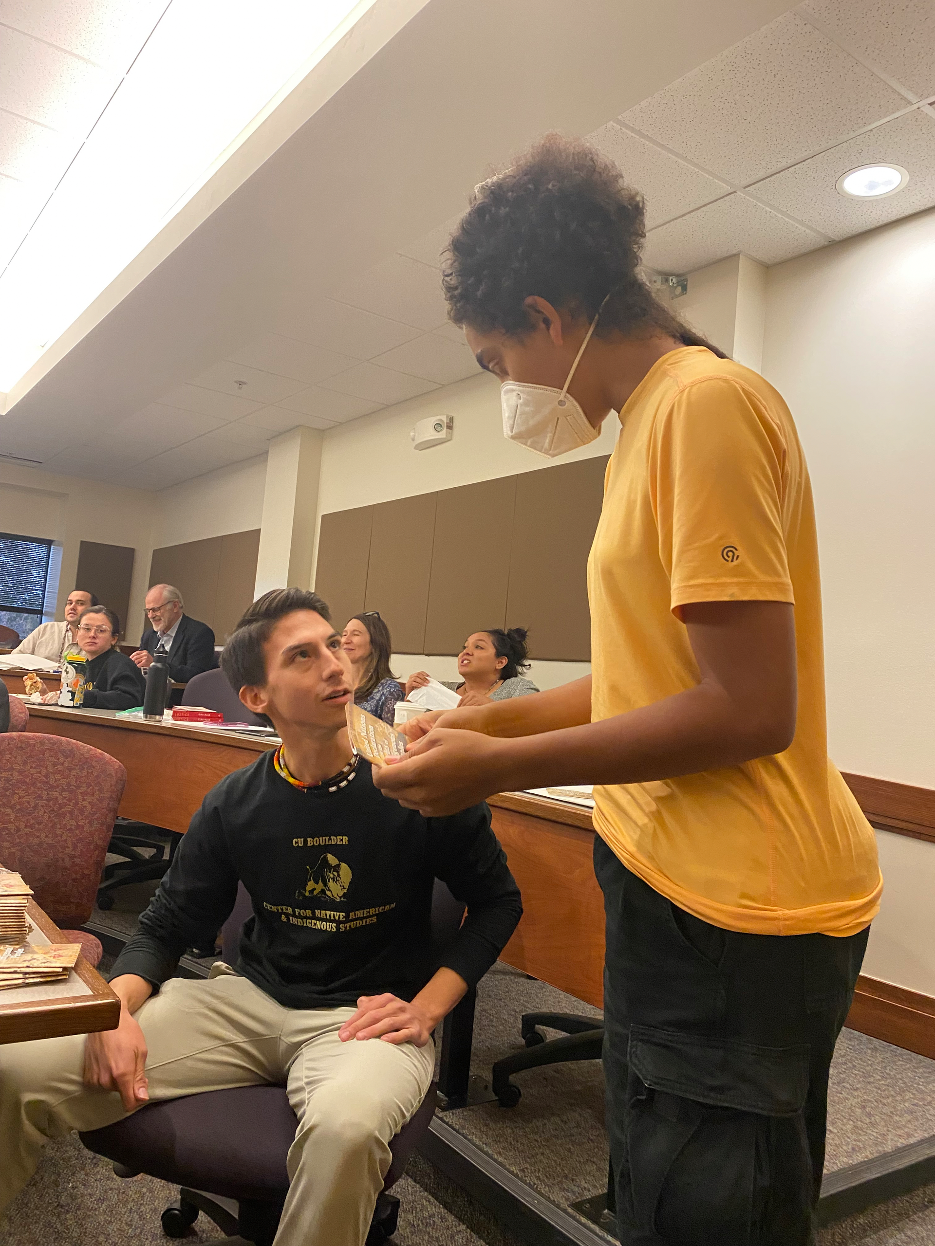 Law student Josh Bertalotto of the Tunica Biloxi Tribe talks with an audience member at an Indigenous youth event.