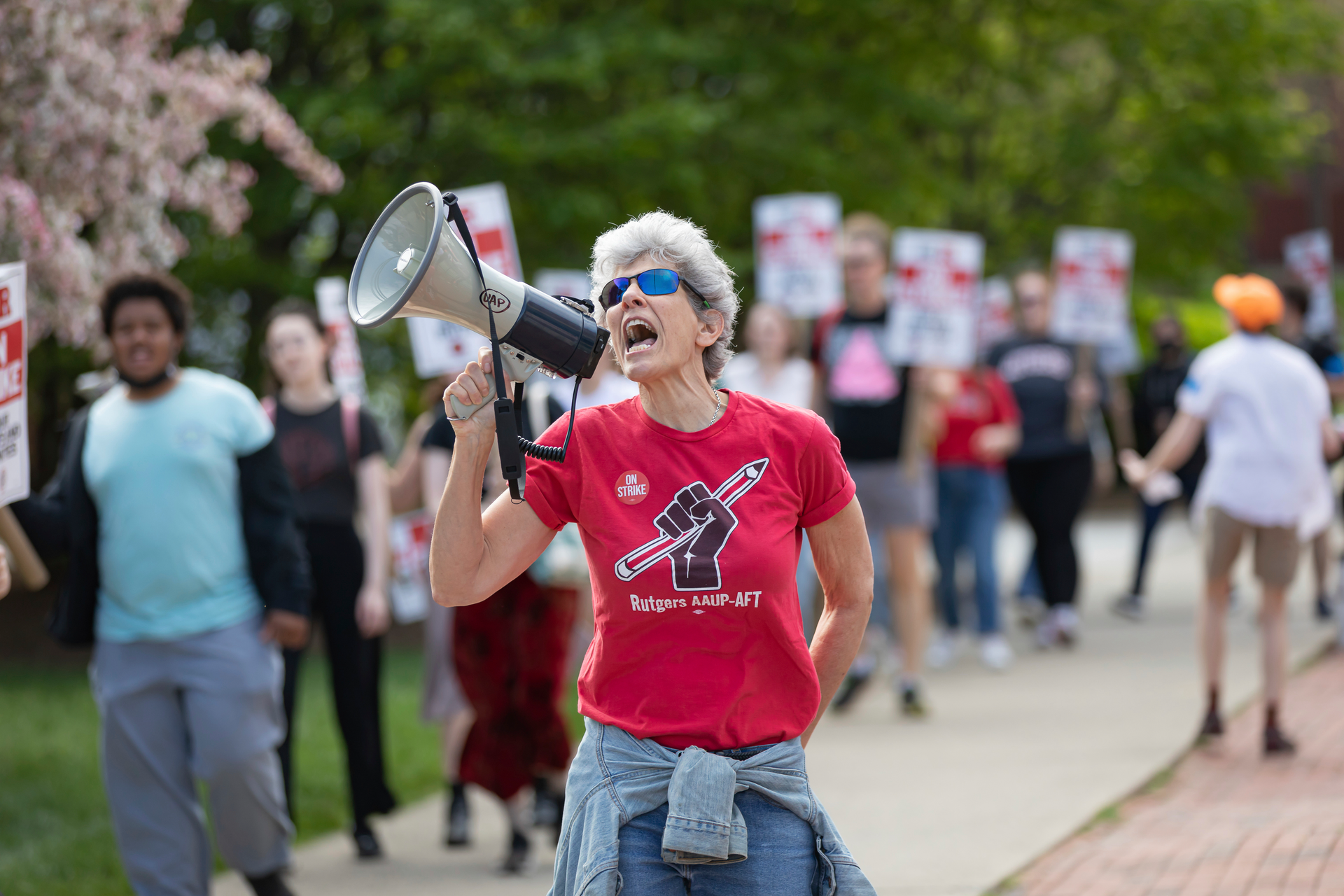 A protester with a bullhorn leads chants with Rutgers students and faculty as they participate in a strike at the university's main campus on April 12, 2023 in New Brunswick, New Jersey. The three faculty unions representing approximately 9,000 workers at Rutgers University, the state university of New Jersey, went on strike after failing to reach a contract in negotiations with Rutgers President Jon- athan Holloway's administration. The walkout is the first in the public university's 257-year history and follows nearly a year of bargaining for increased wages and better contracts. (Photo by Michael Nigro/Sipa USA)(Sipa via AP Images)