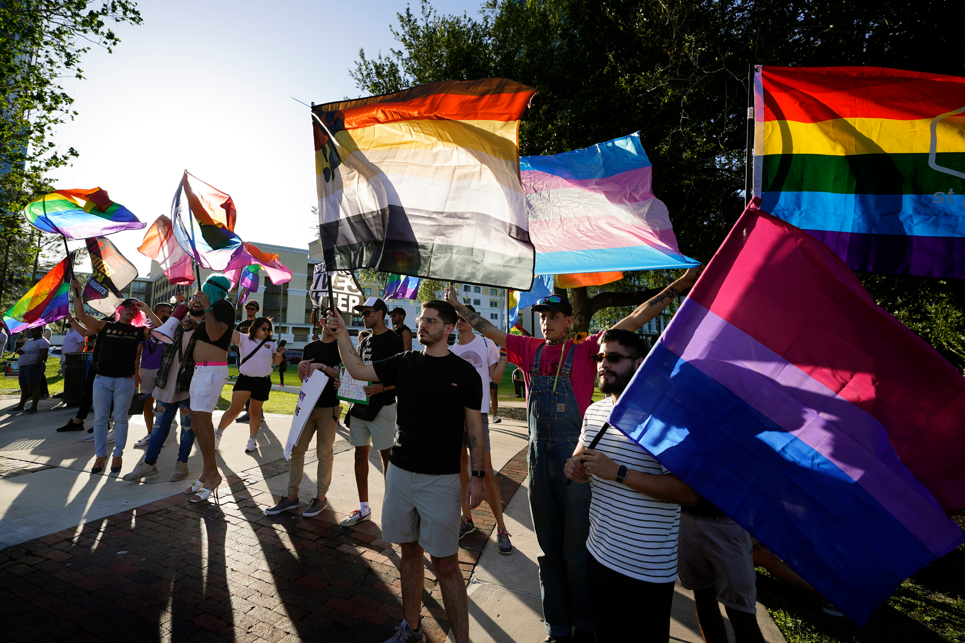 Protesters wave pride flags as they join others, including immigrants rights and abortion rights groups and members of the LGBTQ community from across the state in a rally and march, Monday, May 1, 2023, in Orlando, Fla.