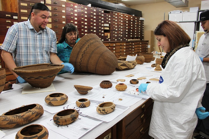 The San Diego Museum of Us' registrar and collections manager working with members of the Kashia Band of Pomo Indians of the Stewarts Point Rancheria, California, during a NAGPRA-based visit to collections.
