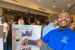 Jordan, a CEES student, shares his experiences on UC’s campus during a poster board presentation.