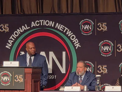 Dr. Jamal Watson looks on as Dr. Michael Eric Dyson delivers remarks during a panel of scholars gathered at this year's National Action Network convention in New York City.