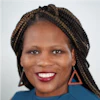 Professional headshot of a smiling woman with braided hair wearing a blue top and triangular earrings