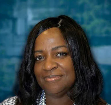Professional headshot of a woman with long black hair smiling at the camera against a blurred blue background
