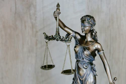 Bronze statue of Lady Justice holding balanced scales and sword, symbolizing law and fairness