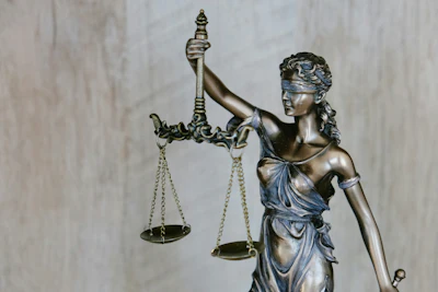 Bronze statue of Lady Justice holding balanced scales and sword, symbolizing law and fairness