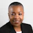 Professional headshot of a woman in a black blazer smiling at the camera against a neutral background
