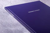 Deep purple dissertation book binding with white text on textured surface