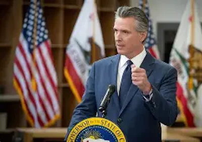 California governor speaking at podium with state seal and American flag in background