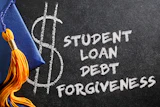 Chalkboard with dollar sign symbol and text reading 'Student Loan Debt Forgiveness' next to graduation cap with gold tassel