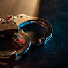 Metal handcuffs with blue and red lighting on dark textured surface