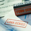Red 'LOAN DENIED' stamps on mortgage and financial documents with borrower signatures