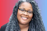 Professional headshot of a woman wearing glasses and black blazer against gradient background