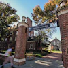 Lafayette College brick gateway entrance with ornate towers flanking a tree-lined campus path