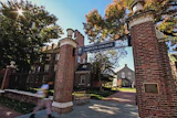 Lafayette College brick gateway entrance with ornate towers flanking a tree-lined campus path