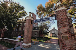 Lafayette College brick gateway entrance with ornate towers flanking a tree-lined campus path