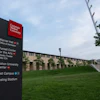 Carnegie Mellon University directional wayfinding sign on campus green space with building and sky in background