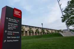 Carnegie Mellon University directional wayfinding sign on campus green space with building and sky in background