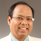 Professional headshot of a smiling man wearing glasses and light-colored shirt