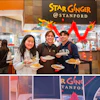 Three Stanford students holding plates of Asian noodle dishes at Star Ginger restaurant with festive red decorations