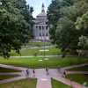 University campus quad with neoclassical building framed by trees and brick pathways