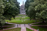University campus quad with neoclassical building framed by trees and brick pathways