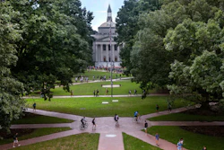 University campus quad with neoclassical building framed by trees and brick pathways