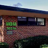 WBAV 903 FM radio station signage on brick building exterior with windows and hedges