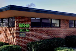 WBAV 903 FM radio station signage on brick building exterior with windows and hedges
