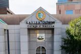 Xavier University College of Medicine building entrance with institutional seal and signage on white stone facade